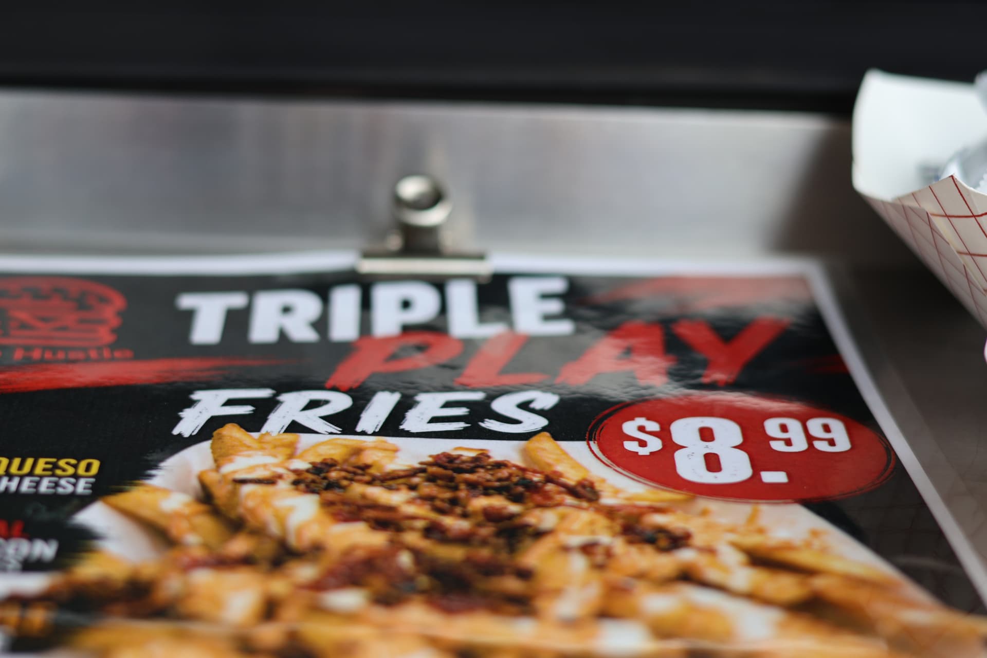 Slide Hustle Triple Play Fries sign at the serving counter